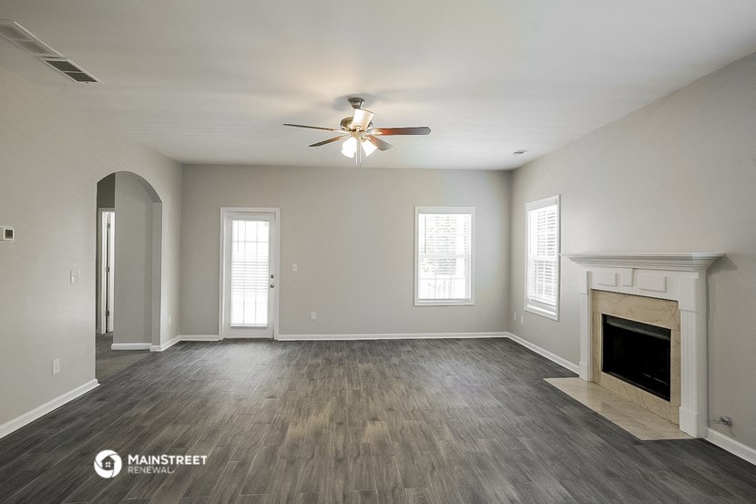 the living room with fireplace and ceiling fan