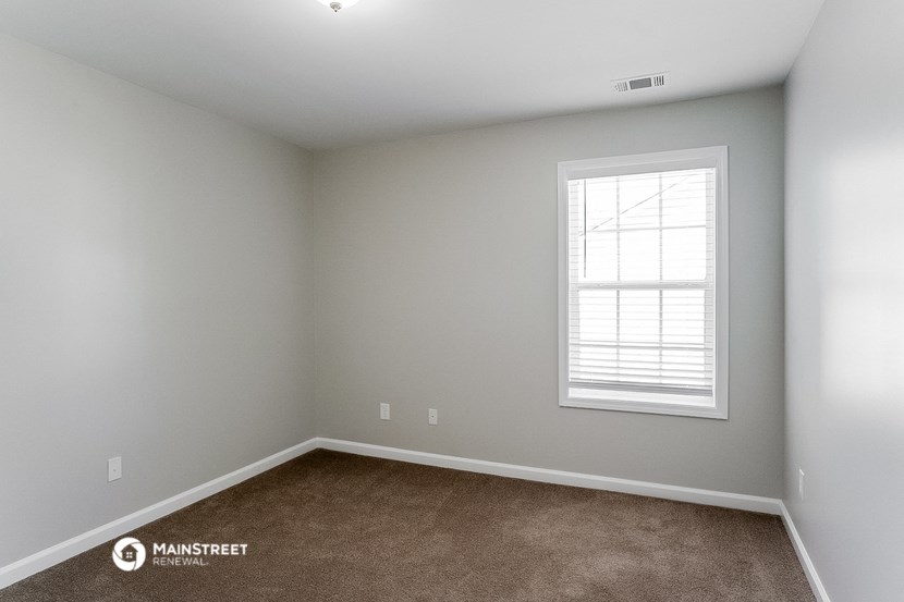 a room with a window and a carpet