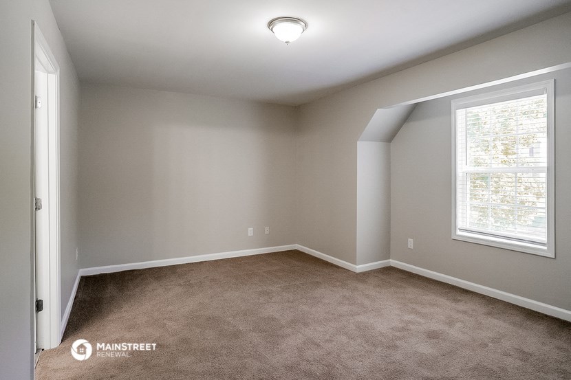 a bedroom with a carpeted floor and a large window