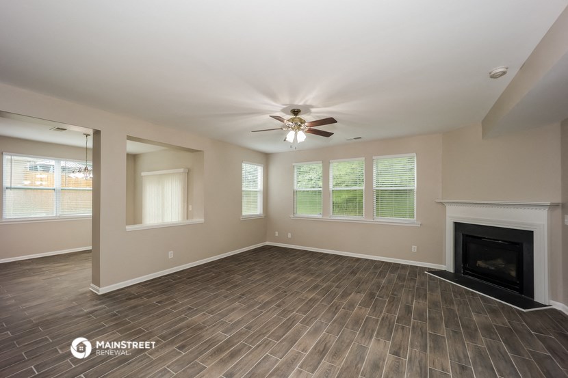 a living room with a fireplace and a ceiling fan