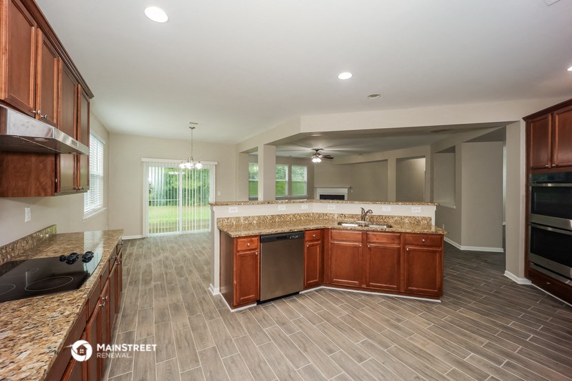 an empty kitchen with wooden cabinets and granite counter tops