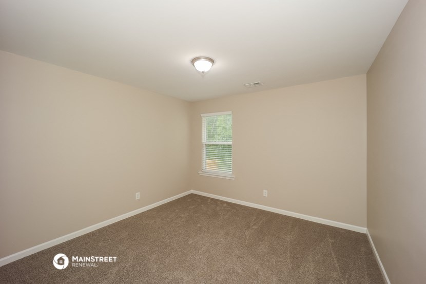 an empty room with carpet and a window