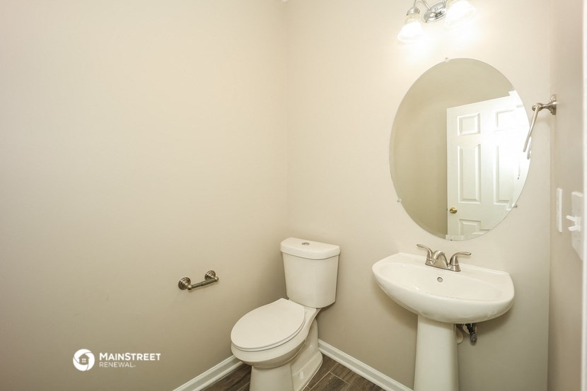 a bathroom with a toilet and a sink and a mirror