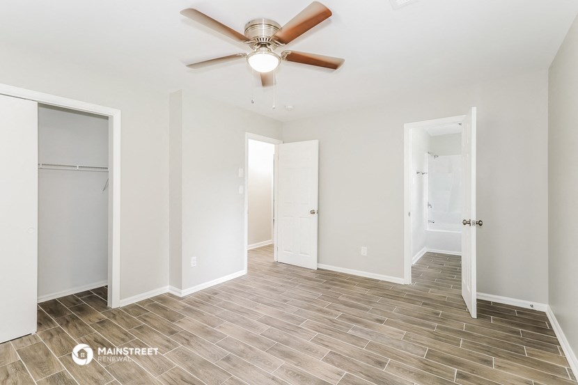 a bedroom with a ceiling fan and a closet