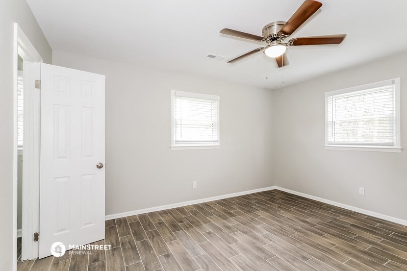 an empty room with a ceiling fan and a door
