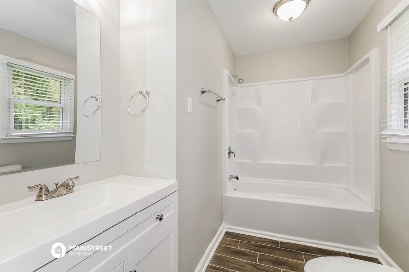 a bathroom with a tub and a sink and a mirror