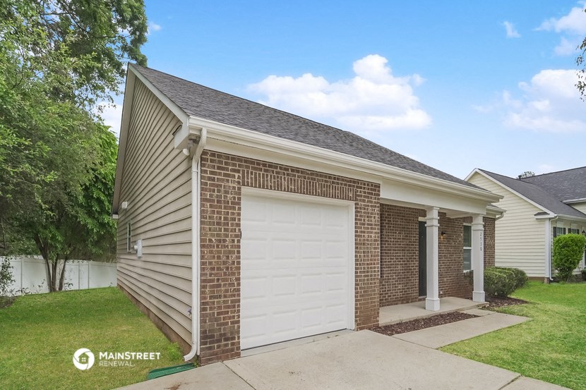 a small brick house with a white garage door