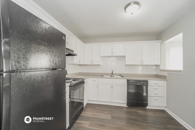 a white kitchen with stainless steel appliances and white cabinets