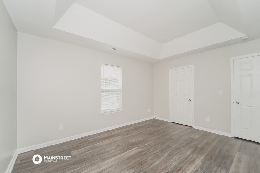 the living room of a new home with white walls and wood floors