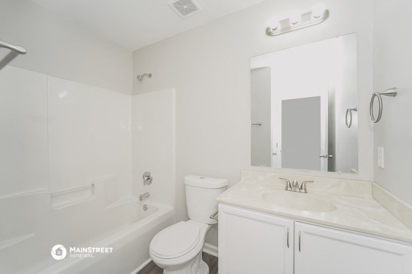 a white bathroom with a sink and a toilet and a tub
