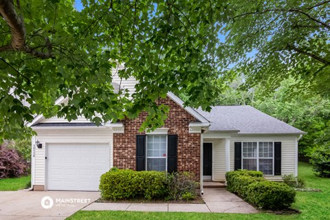a small brick house with a white garage door