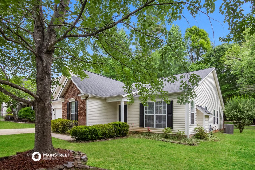a white house with a large tree in front of it