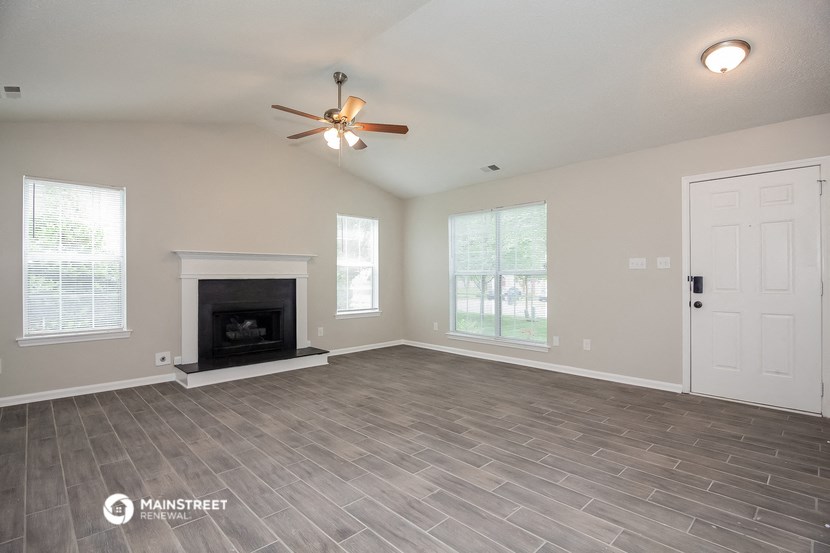 the living room with fireplace and ceiling fan