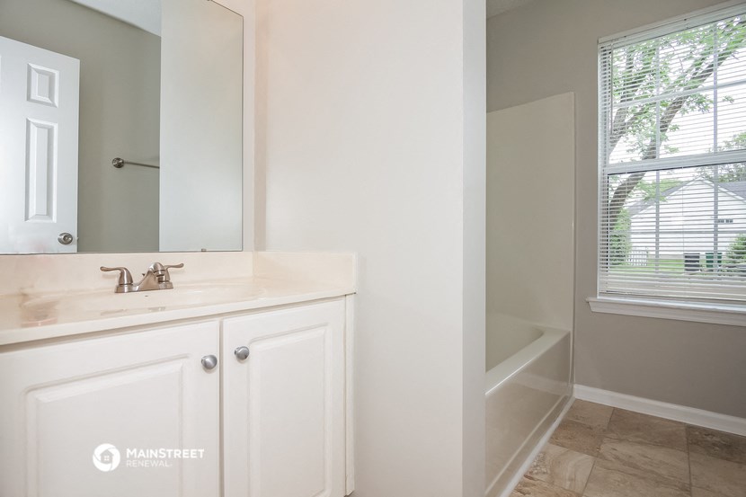 a bathroom with a sink and a mirror and a tub