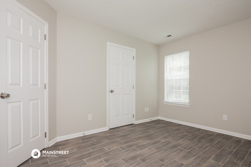 the spacious living room with a door to the bedroom