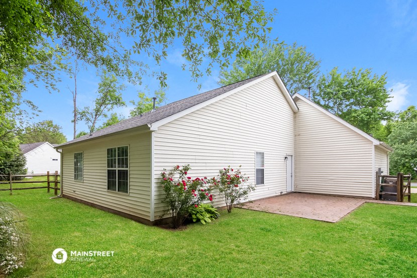 a small white house with a yard and a backyard