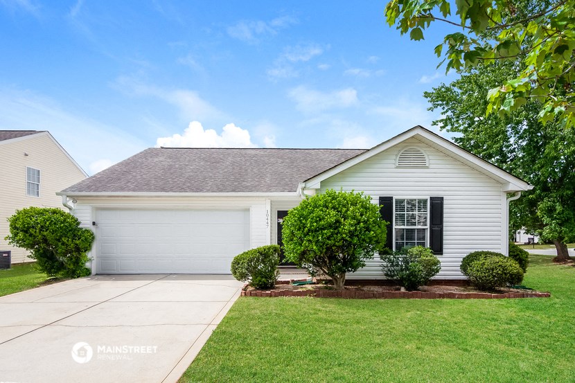 a white house with a lawn and a driveway