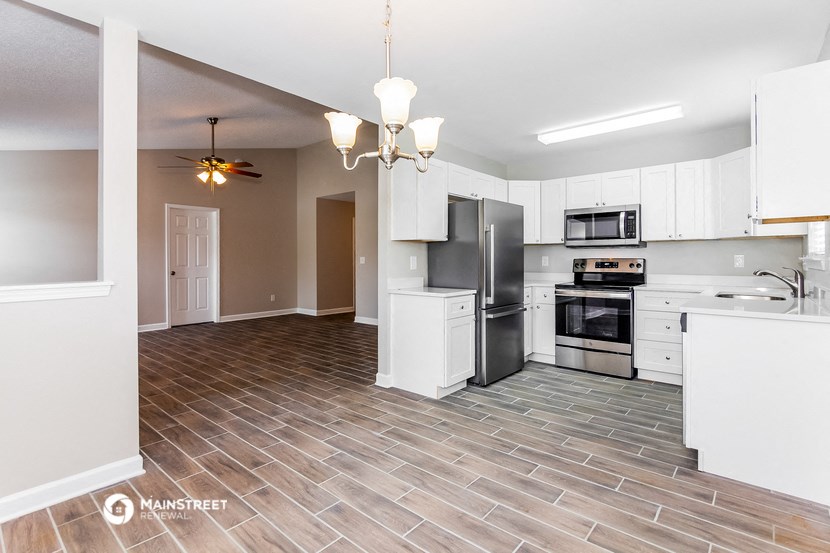 an empty kitchen with white cabinets and stainless steel appliances