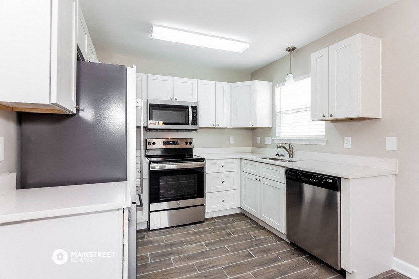 a white kitchen with stainless steel appliances and white cabinets