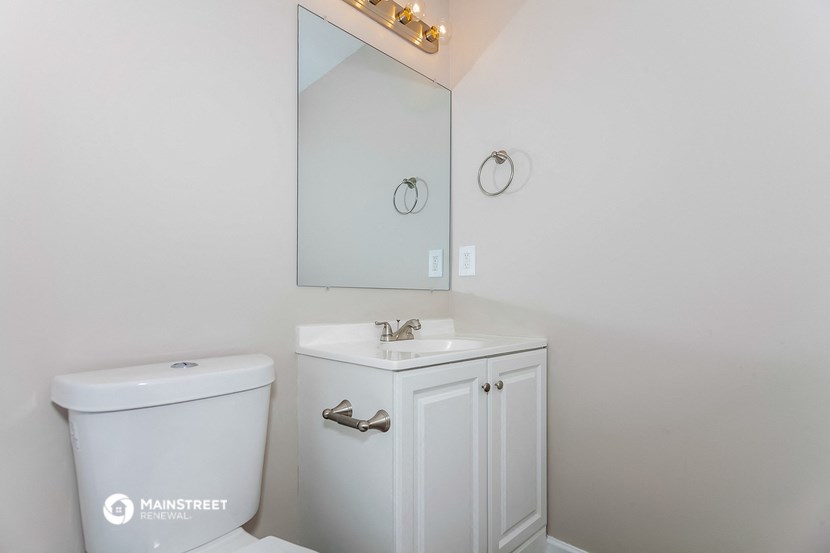 a white bathroom with a white toilet and a sink