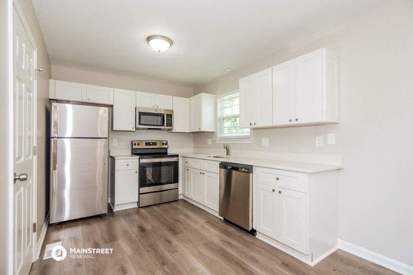 a kitchen with white cabinets and stainless steel appliances