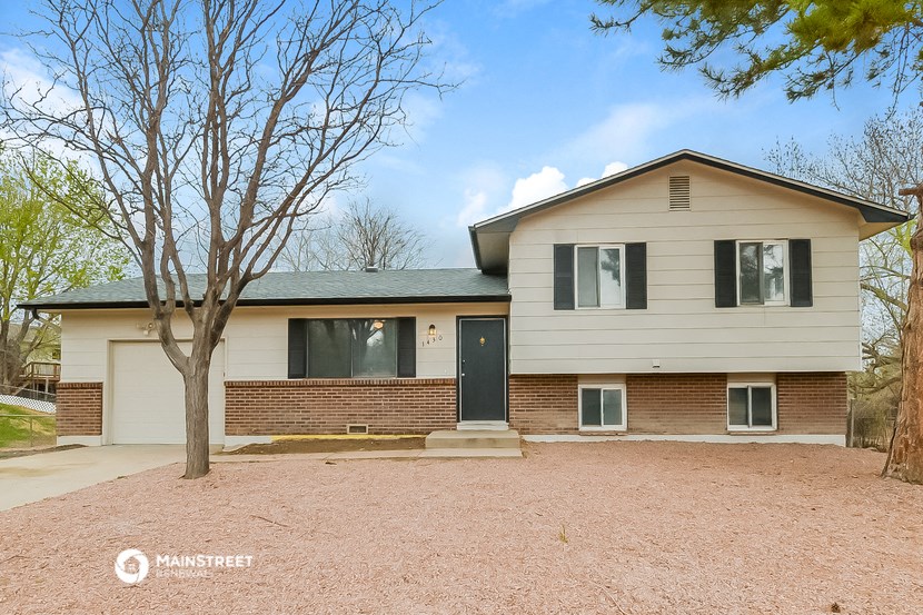a white and brick house with a gravel driveway