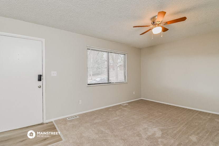 an empty room with a ceiling fan and a window