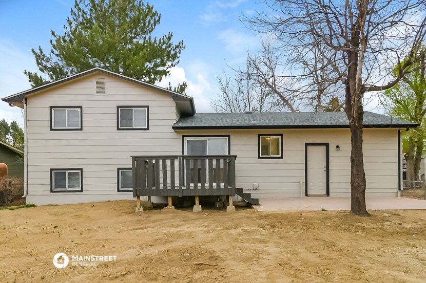 a wooden deck in front of a white house