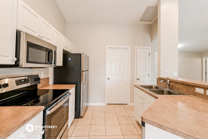 a kitchen with stainless steel appliances and white cabinets