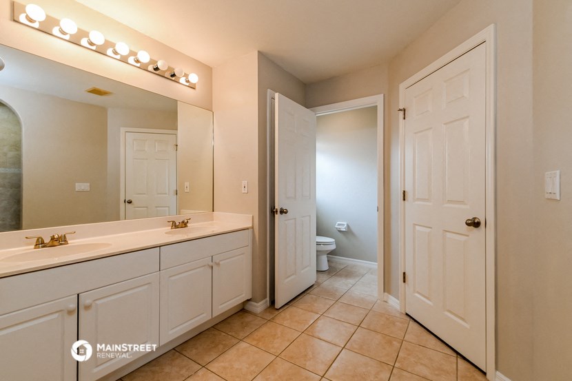a bathroom with white cabinets and a sink and a toilet