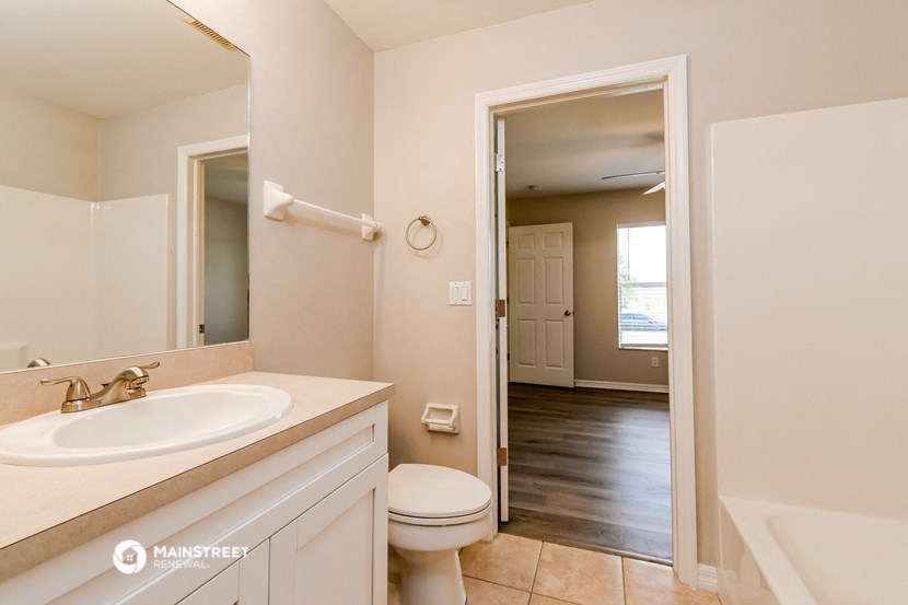 a bathroom with a toilet and a sink and a mirror