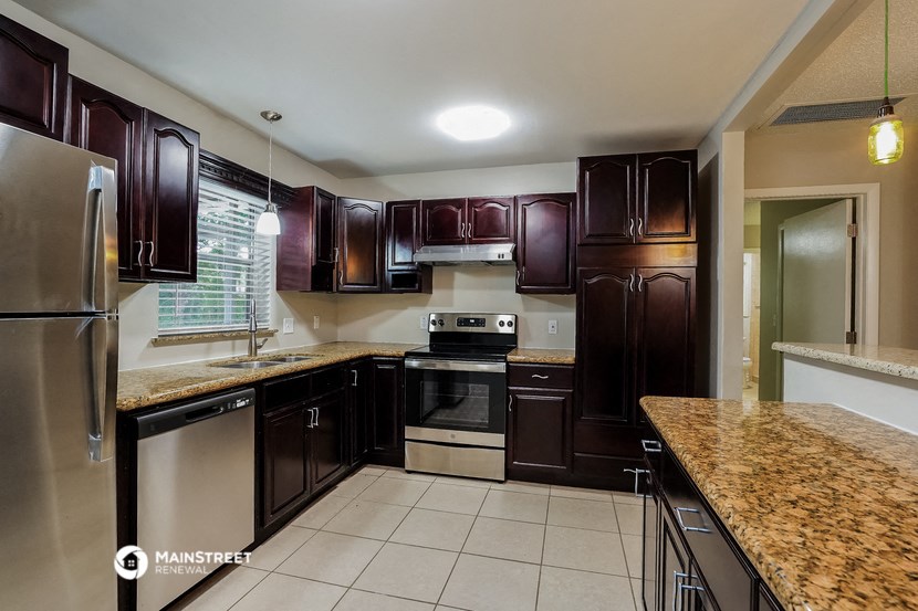 a kitchen with dark wood cabinets and granite counter tops