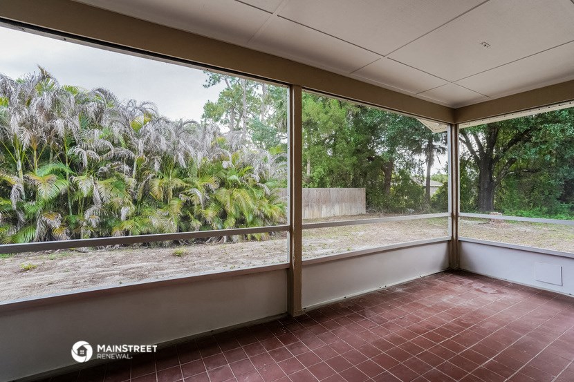 a room with large windows and a view of a garden