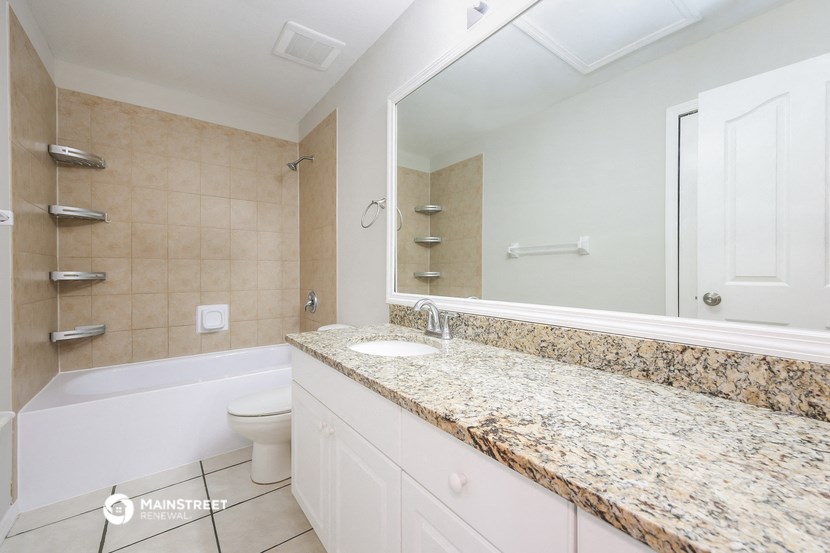a bathroom with a large mirror and a toilet and a sink