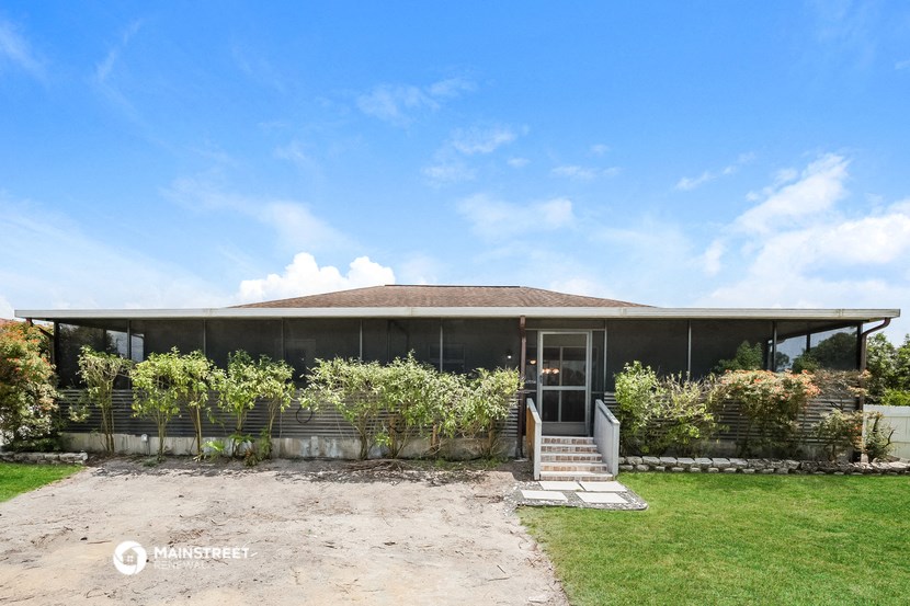 the front of a house with a porch and a lawn