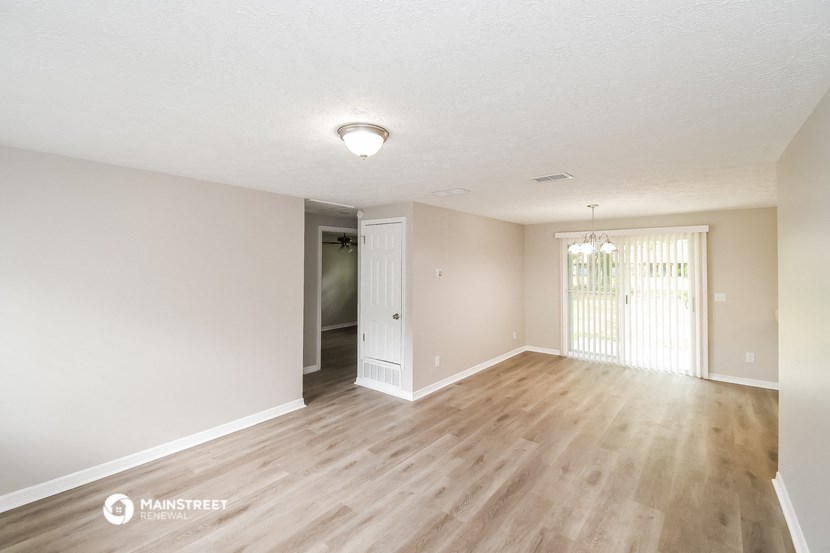 the spacious living room and dining room of an apartment