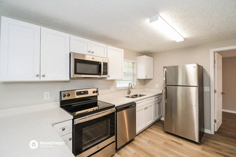 a kitchen with stainless steel appliances and white cabinets