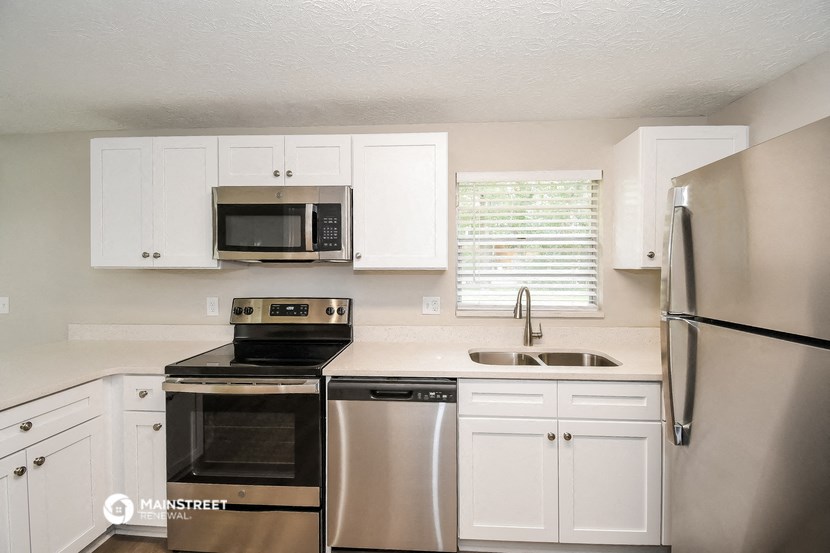 a kitchen with stainless steel appliances and white cabinets