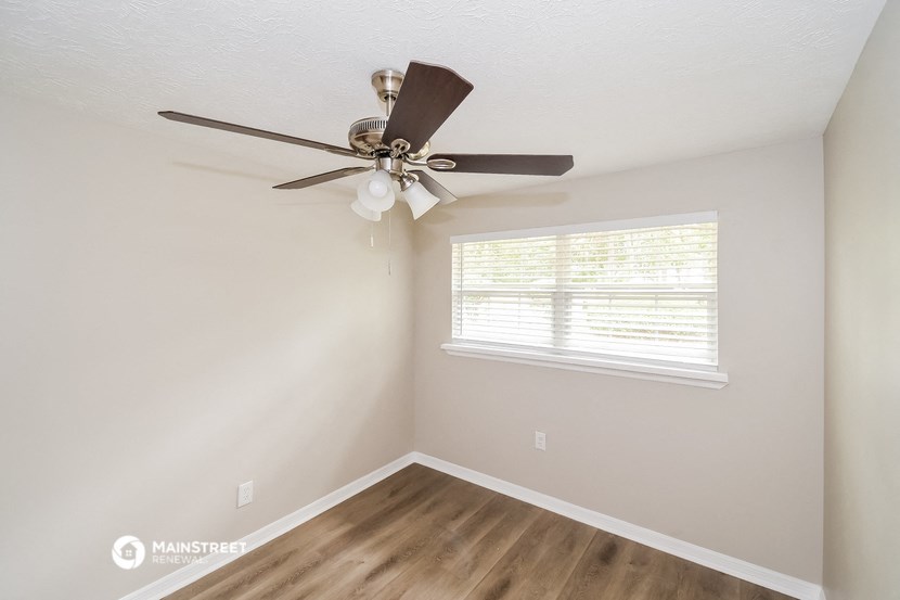 a bedroom with a ceiling fan and a window