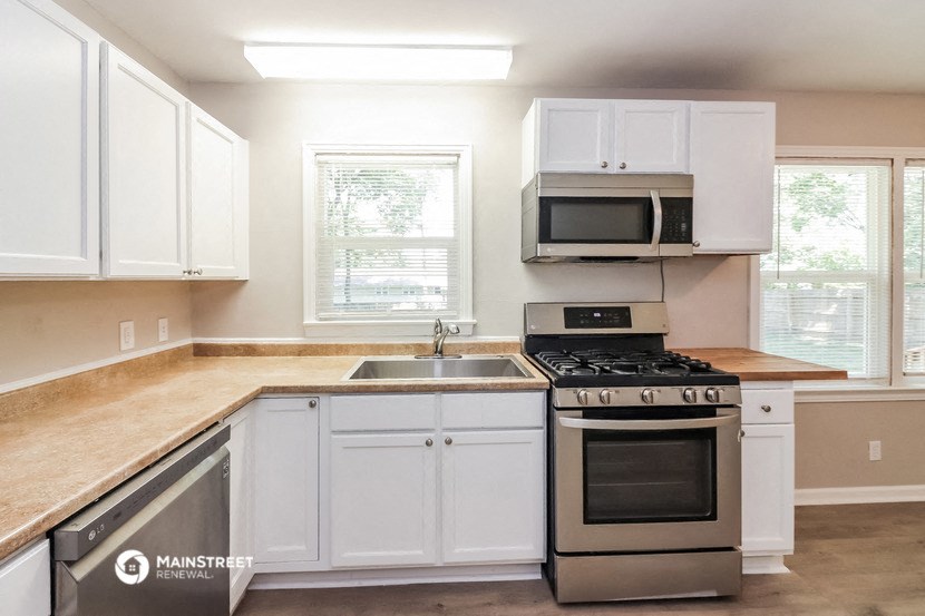 a kitchen with white cabinets and a stove and a sink