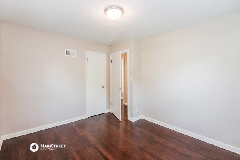 a living room with wood flooring and white walls