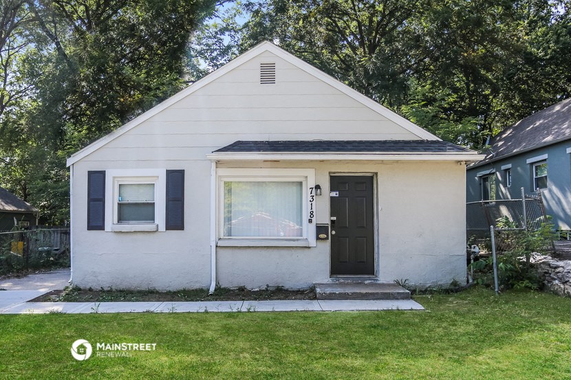 a white house with black shutters and a black door