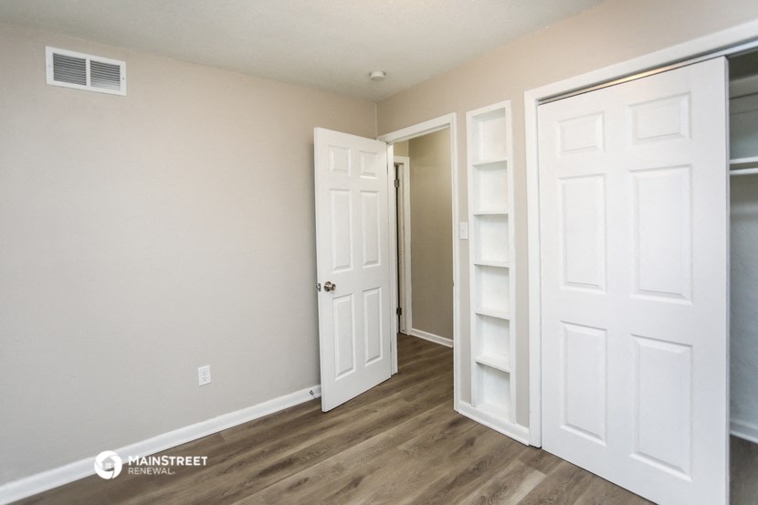 a bedroom with two closets and a door into a hallway
