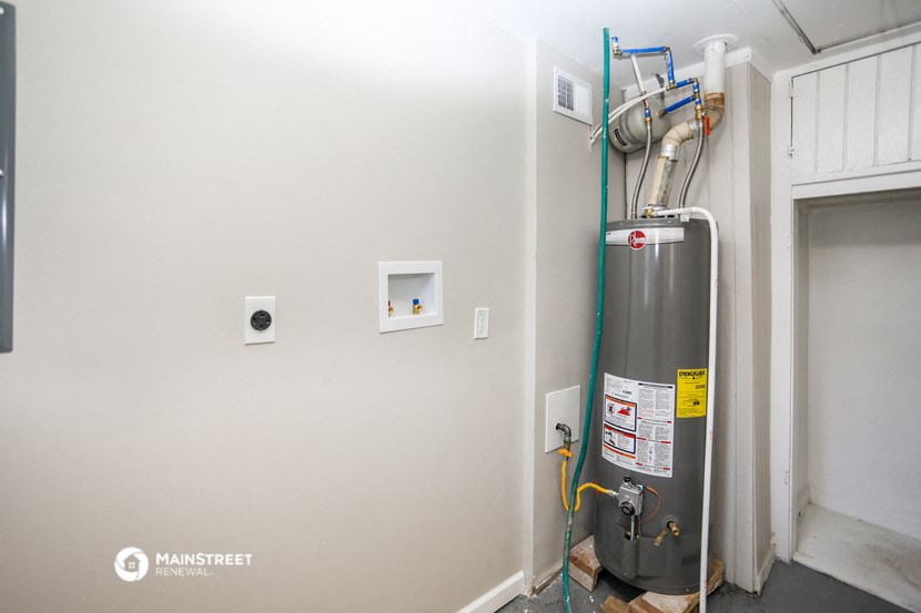 a boiler in the corner of a room next to a wall