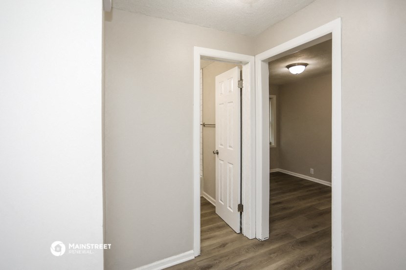a bedroom with a door open to a hallway and a door to a closet