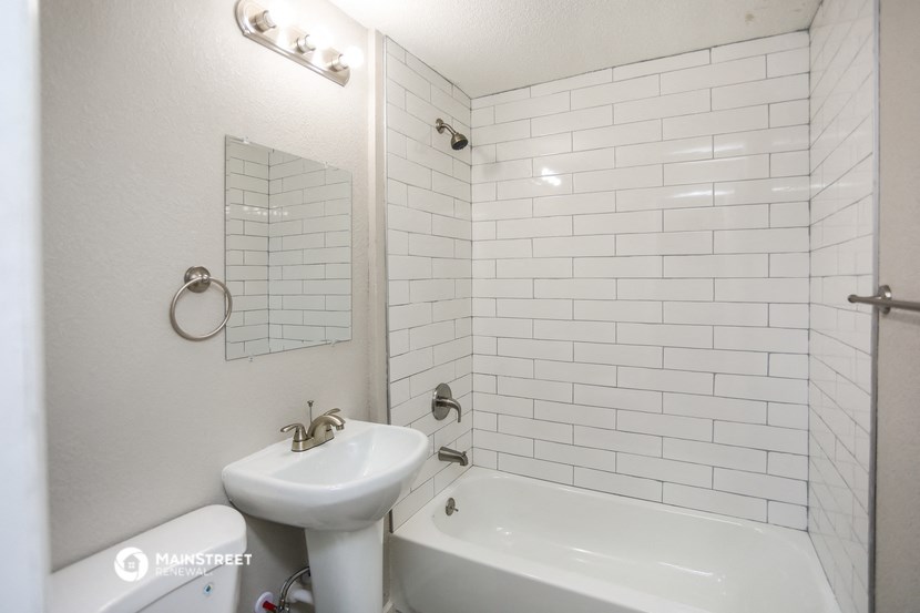 a white bathroom with a sink and a tub