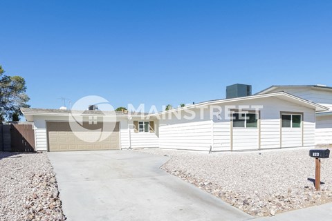 a white house with a driveway and a parking meter