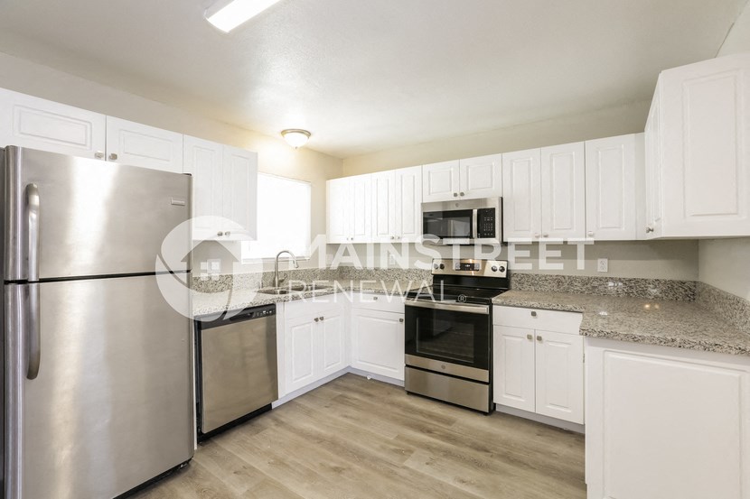 a kitchen with white cabinets and stainless steel appliances