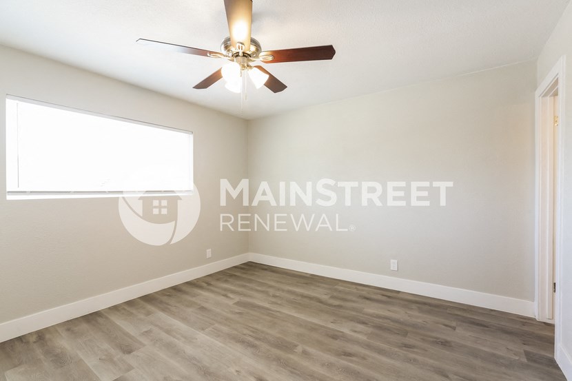 a living room with a ceiling fan and a window