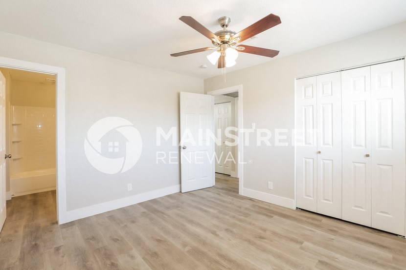 a bedroom with two closets and a ceiling fan